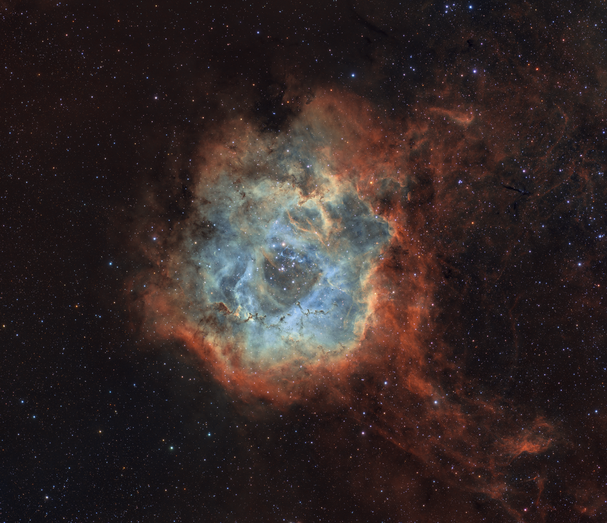 A circular space nebula in reds, oranges and blues.